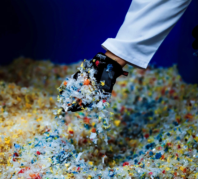 A hand going through the treated polymer flake dispensed in the receptacle