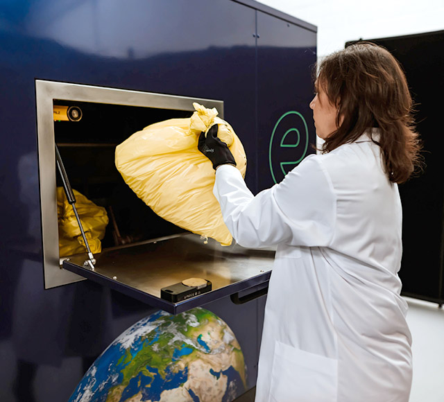 A technician loading a bag into the receiver of Envetec GENERATIONS