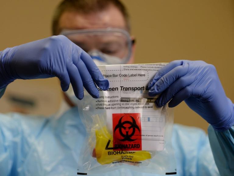 Scientist holding a biohazardous waste bag